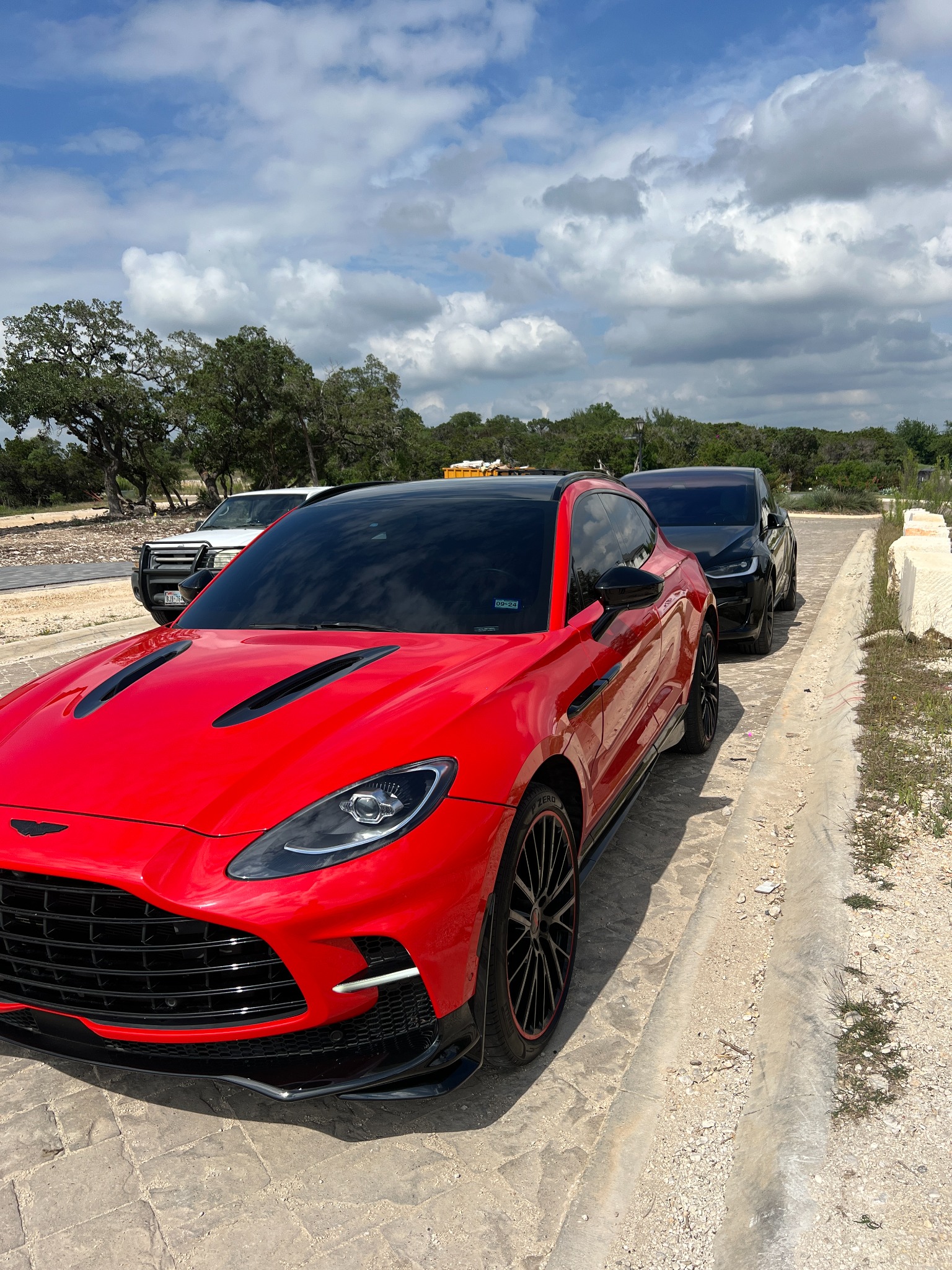 Red Aston Martin SUV with dark tinted windows