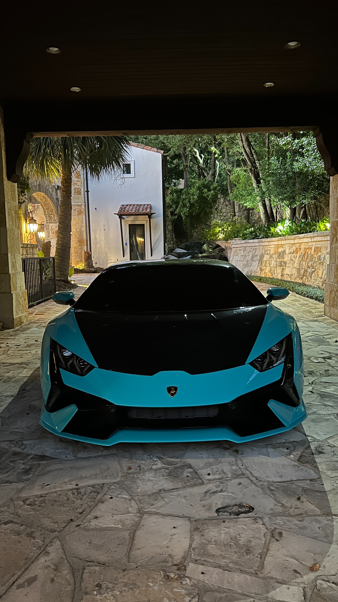 Blue Lamborghini with dark window tint at night